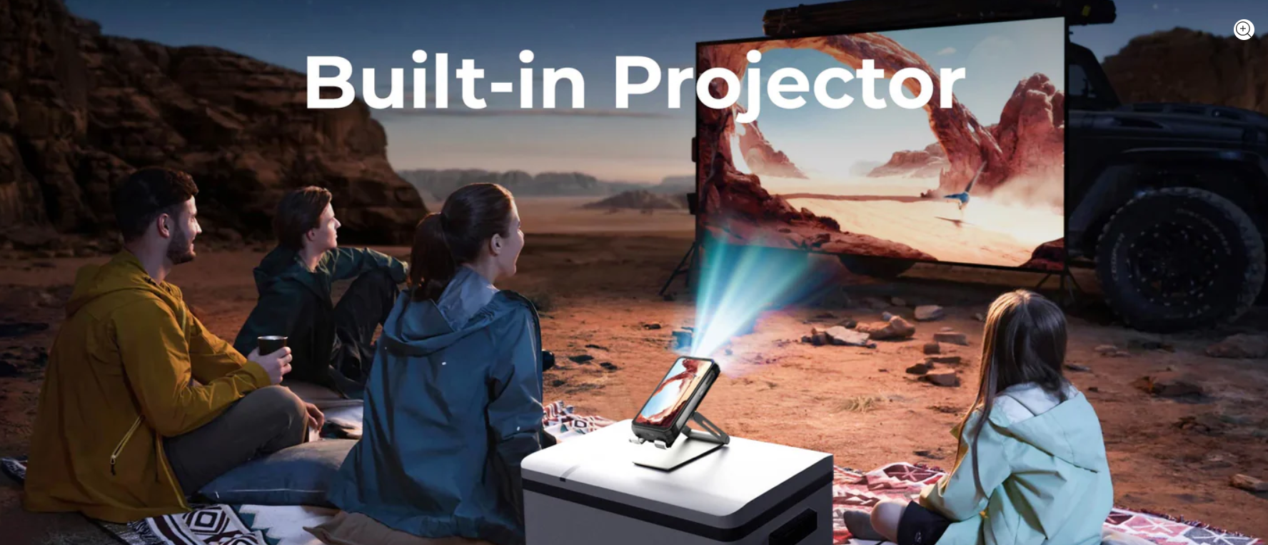 People watching a movie projected by a built-in projector in a desert setting.